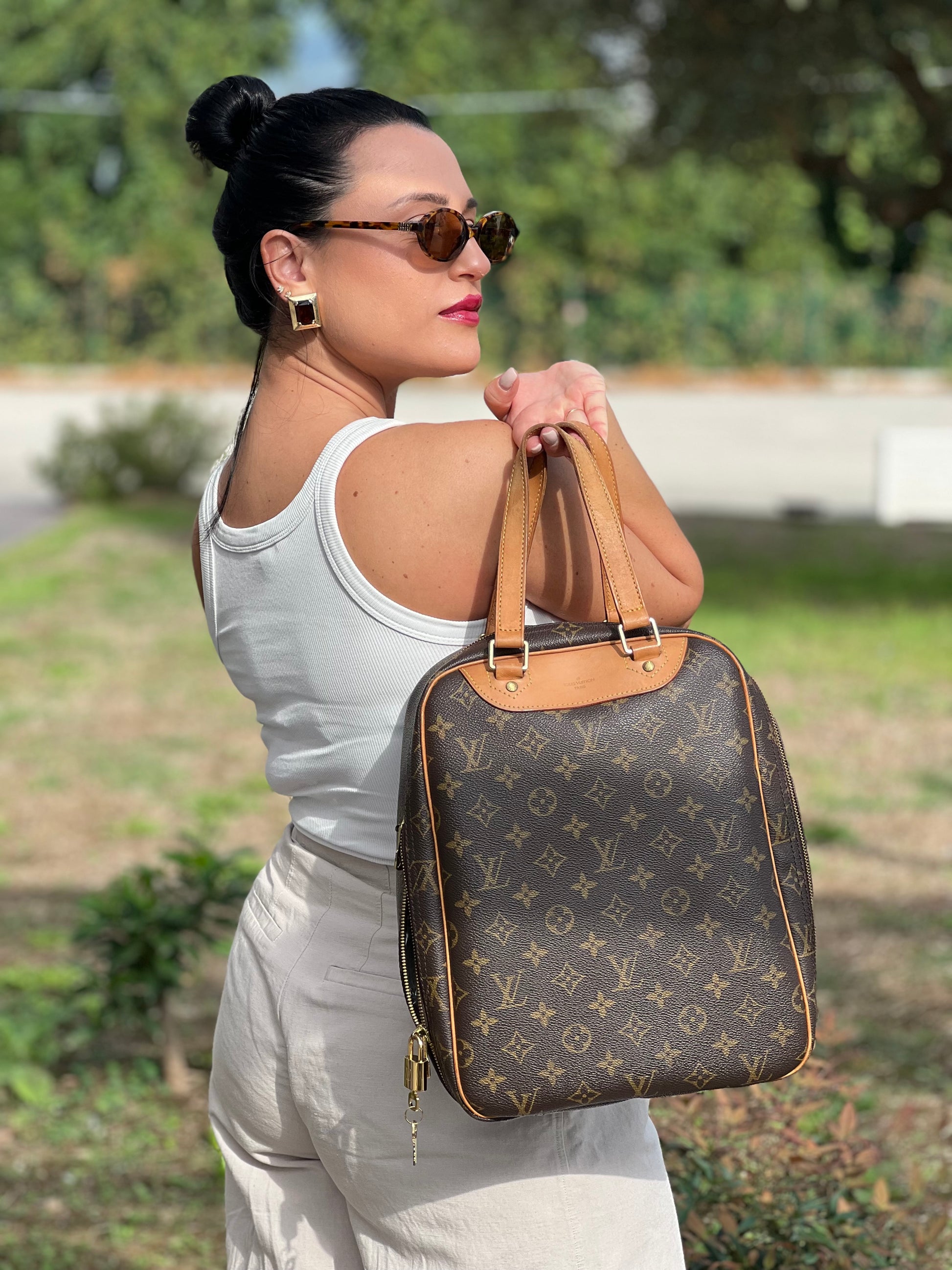 Borsa Louis Vuitton Excursion in canvas marrone monogram con finiture in vacchetta naturale e parti metalliche dorate. Da portare a mano. Completa di dustbag. Originale, usato, in condizioni ottime. 