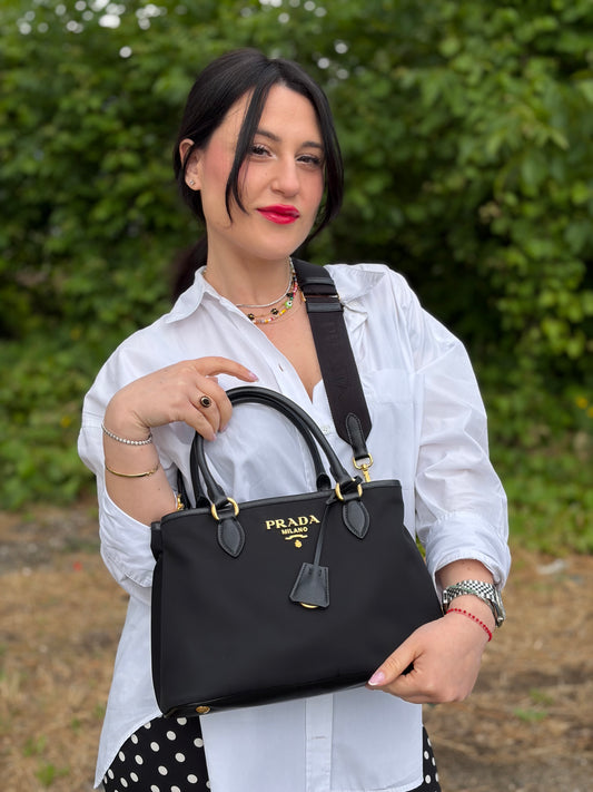 Borsa Prada in nylon nero con finiture in pelle saffiano tono su tono; munita di doppi manici stondati e una tracolla logata in tessuto regolabile ed amovibile, di lusso, originale, ottime condizioni, usata.