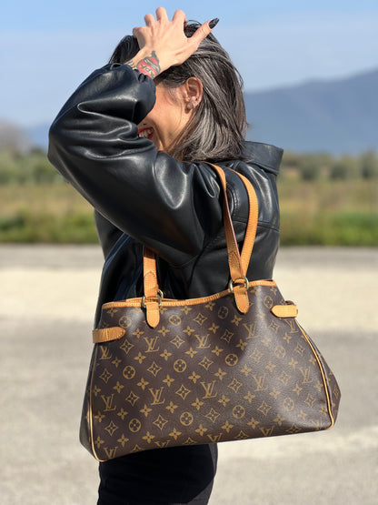 Ragazza che indossa una borsa LV in canvas marrone monogram con finiture in vacchetta naturale e dettagli metallici dorati. Dotata di dustbag.