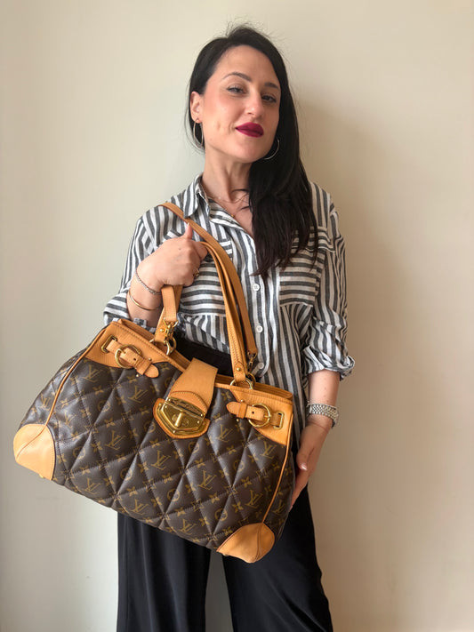 Ragazza che indossa una borsa Etoile LV in canvas trapuntato monogram, indossabile a spalla o a tracolla, usata, originale, second hand, in ottime condizioni.