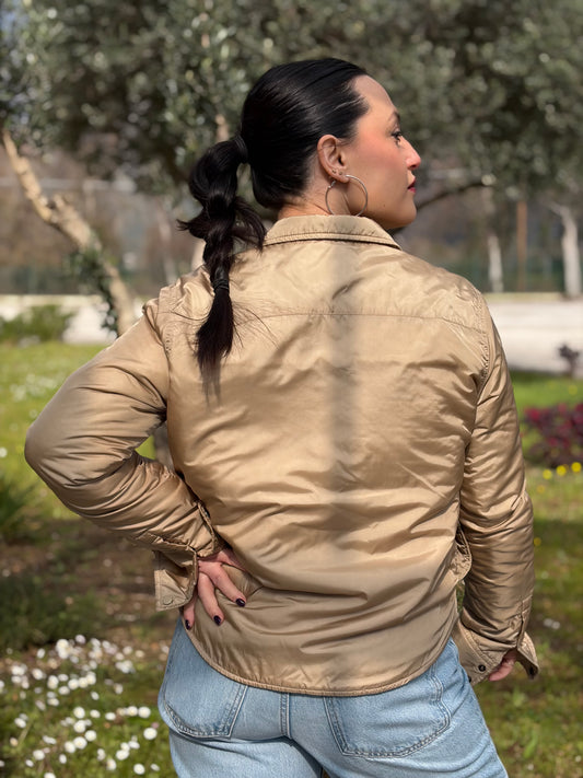Ragazza che indossa una camicia leggermente imbottita Aspesi in una calda colorazione beige, usata, originale, second hand, in ottime condizioni.