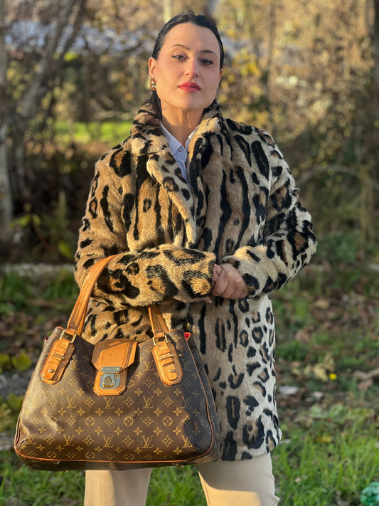 Ragazza che indossa una borsa Griet LV in canvas marrone monogrammato, con finiture in vacchetta naturale e metalleria dorata. Indossabile a spalla oppure a mano.