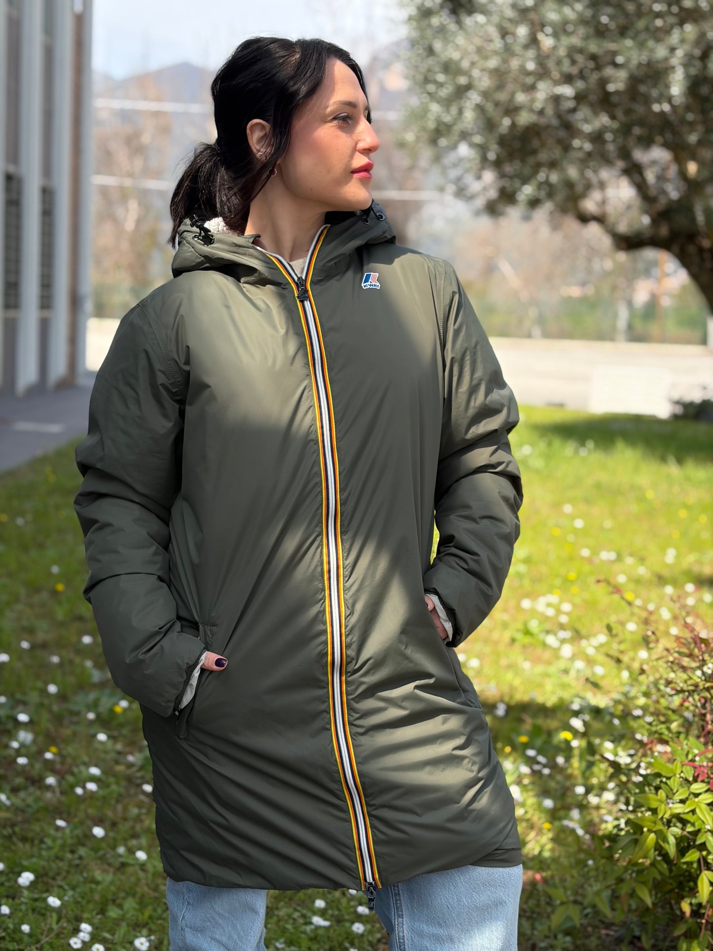 Ragazza che indossa un giubbino K-Way in 100% poliammide verde oliva, con morbido effetto shearling nella fodera interna,usato, originale, second hand, in ottime condizioni.