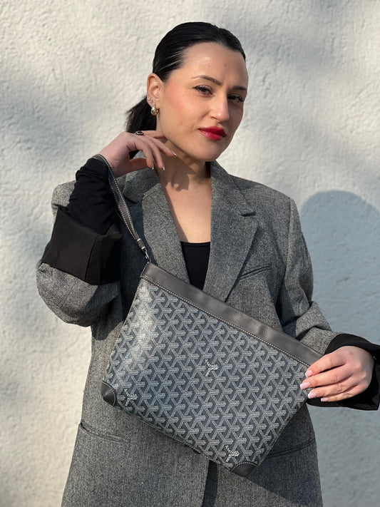 indossata  Pochette Goyard in canvas trama Goyardine nelle tonalità dei grigi con parti metalliche argentate; munita di un polsino, indossabile a mano. Completa di dustbag e busta, di lusso, originale, ottime condizioni. 