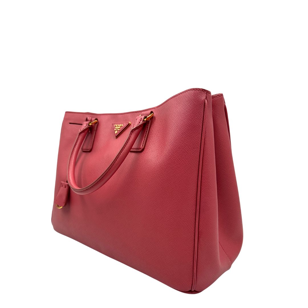 lato Borsa Prada in pelle saffiano rosa con hardware dorato, munita di doppi manici stondati, di lusso, originale, ottime condizioni, usata 