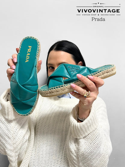 Scopri i sandali espadrillas Prada in pelle verde acqua, perfetti per un look estivo raffinato e confortevole. Con dettagli intrecciati e suola in corda, uniscono eleganza e praticità per le giornate più calde.