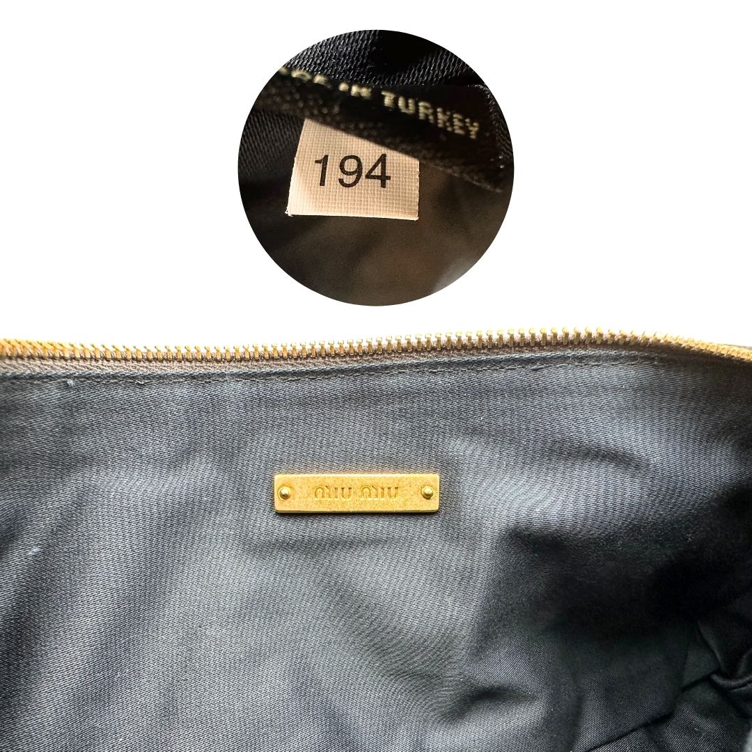 codice Pochette Miu Miu in pelle matelassè grigia effetto invecchiato con parti metalliche dorate; munita di un polsino, da portare a mano, di lusso, originale, ottime condizioni. 