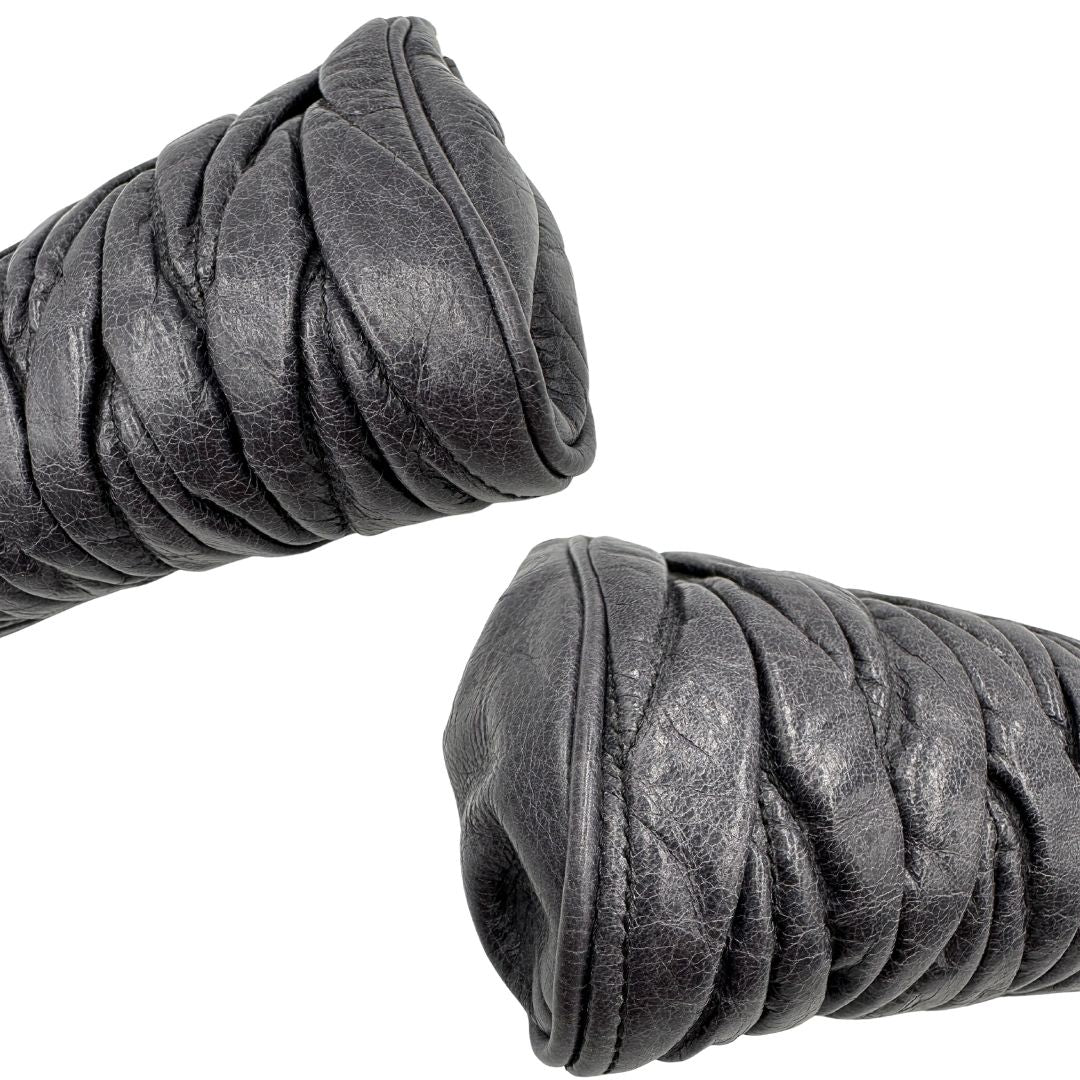 angoli Pochette Miu Miu in pelle matelassè grigia effetto invecchiato con parti metalliche dorate; munita di un polsino, da portare a mano, di lusso, originale, ottime condizioni. 