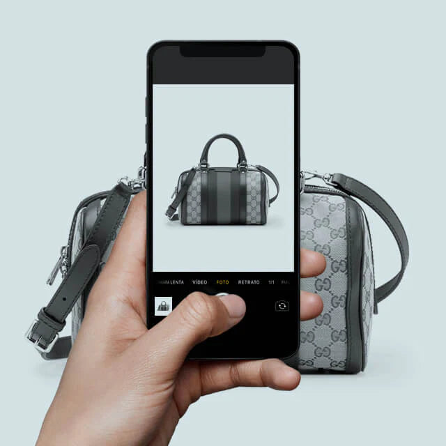 Una mano fotografa con lo smartphone una borsa firmata, primo passo per venderla