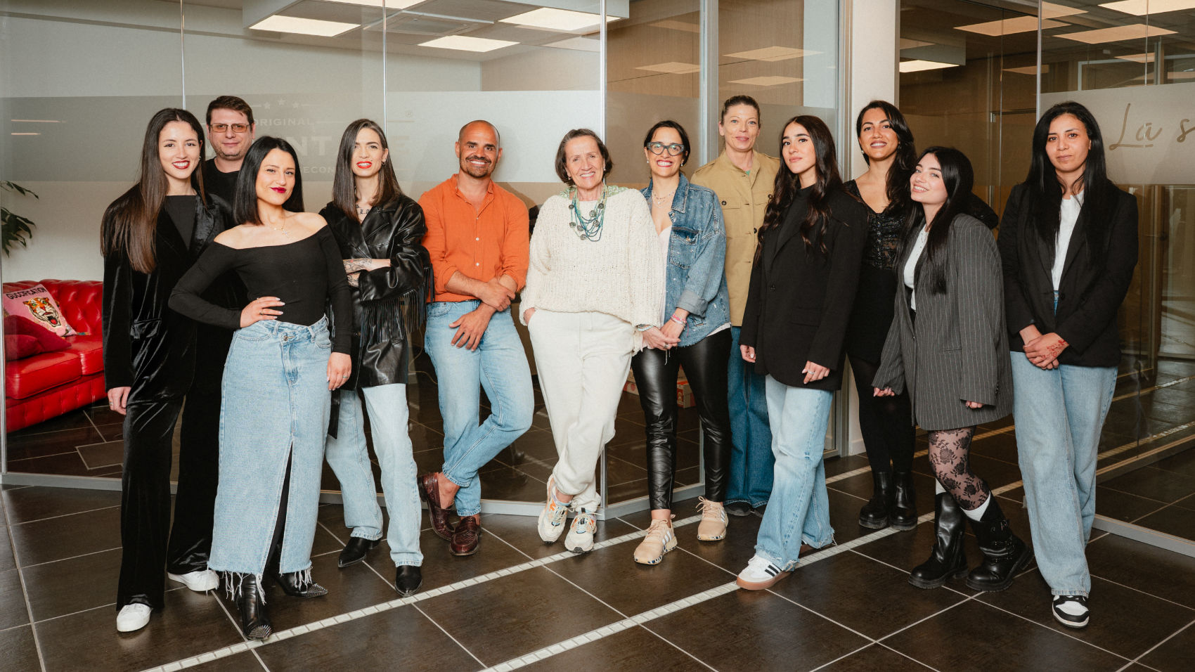 Foto di gruppo del team VivoVintage in posa davanti agli uffici aziendali. Il team è composto da donne e uomini con competenze in moda, restauro artigianale, autenticazione di borse firmate, e customer care. Immagine che rappresenta l’identità aziendale, la professionalità e l’approccio umano di VivoVintage.