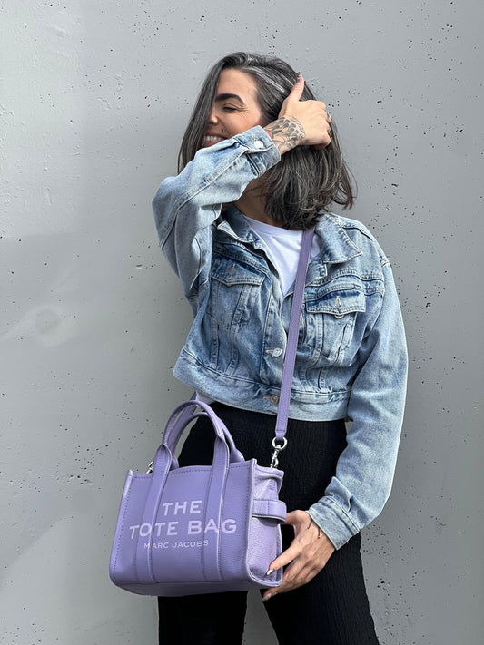 indossata The Tote Bag Marc Jacobs in pelle lilla con parti metalliche argentate; munita di doppi manici e una tracolla amovibile e regolabile. Completa di dustbag, di lusso, originale, ottime condizioni. 
