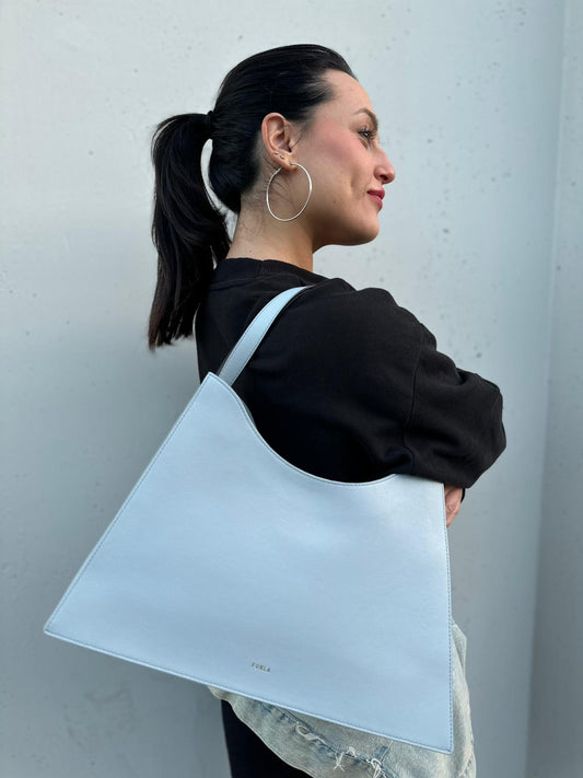 indossata  Borsa Furla Nuvola in pelle azzurro polvere con parti metalliche dorate; munita di un manico regolabile e rimovibile. Originale, usata, di lusso, in eccellenti condizioni