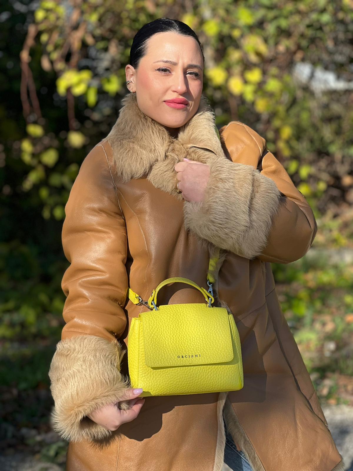 indossata Borsa Orciani in pelle martellata gialla con parti metalliche argentate; munita di un manico singolo e una tracolla amovibile e regolabile, di lusso, originale, ottime condizioni.