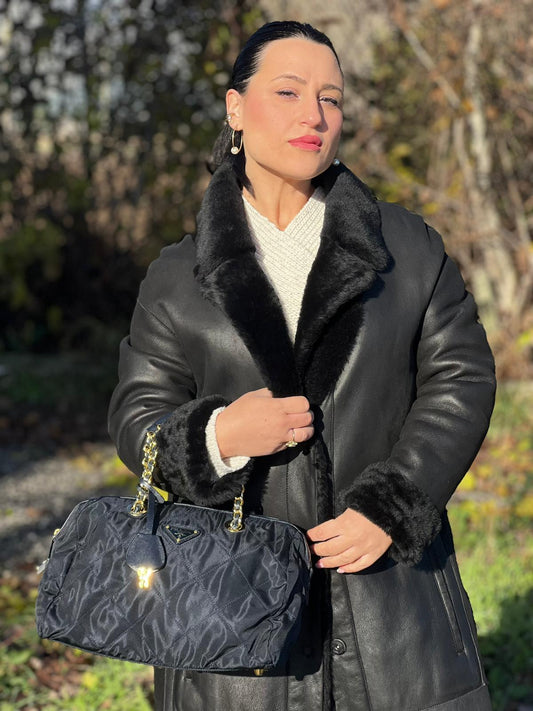 indossata della Borsa Prada in nylon blu con finiture in pelle saffiano tono su tono e parti metalliche dorate; munita di doppi manici in pelle e catena intrecciati. Completa di lucchetto e chiavi, di lusso, originale, usata.