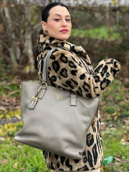 indossata Borsa Prada in pelle grigia martellata con parti metalliche dorate; munita di cerniere laterali e doppi manici, indossabile a spalla, di lusso, originale, ottime condizioni, usata. 