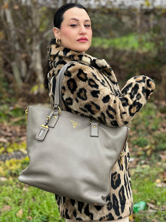 indossata Borsa Prada in pelle grigia martellata con parti metalliche dorate; munita di cerniere laterali e doppi manici, indossabile a spalla, di lusso, originale, ottime condizioni, usata. 