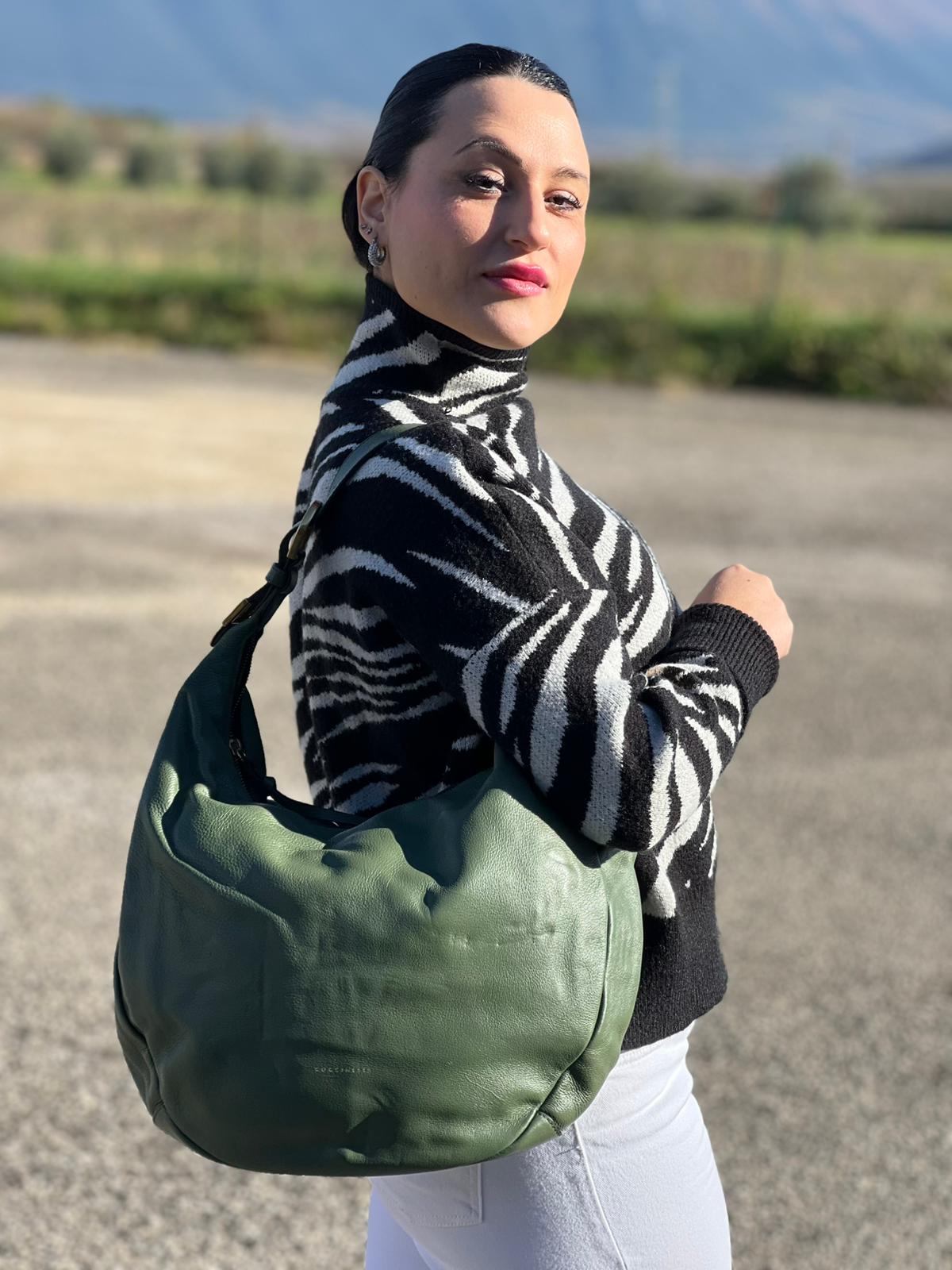 indossata Borsa Coccinelle in pelle martellata verde oliva con parti metalliche dorate; munita di un manico singolo leggermente regolabile. Completa di dustbag, di lusso, originale, ottime condizioni, usata. 