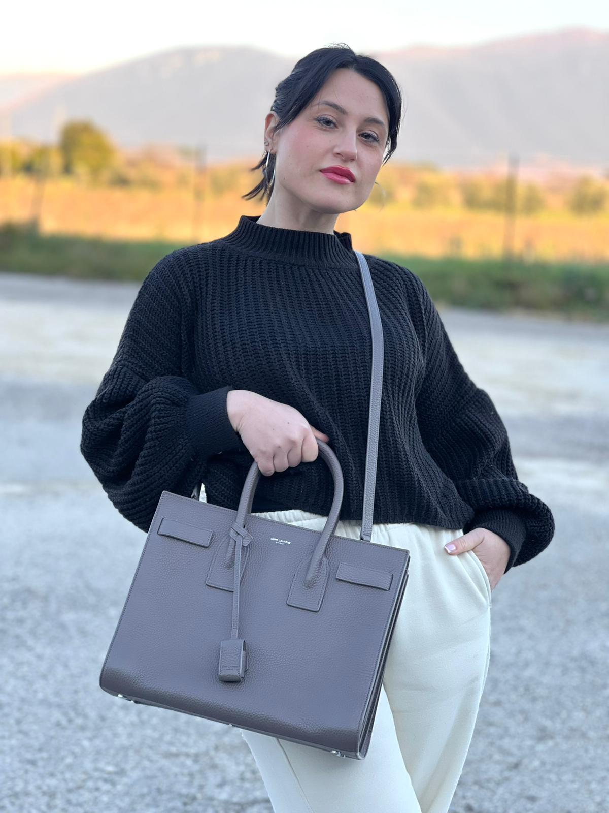 indossata Borsa Saint Laurent in pelle martellata grigia con parti metalliche argentate; munita di doppi manici stondati e una tracolla amovibile. Impreziosita da un lucchetto decorativo, di lusso, originale, ottime condizioni. 