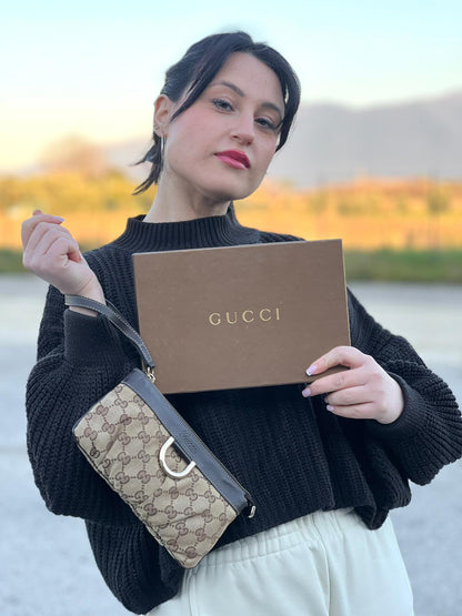 indossata Pochette Gucci in tessuto Gucci in tessuto GG beige con finiture in pelle marroni e parti metalliche dorate; munita di un polsino, da portare a mano. Completa di corredo, di lusso, originale, ottime condizioni. 
