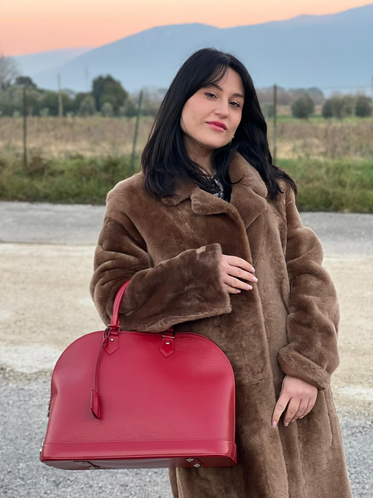 indossata della  Borsa Alma GM Louis Vuitton in pelle Epi rossa con parti metalliche argentate, munita di due manici stondati. Completa di lucchetto e chiavi, di lusso, usata, originale.