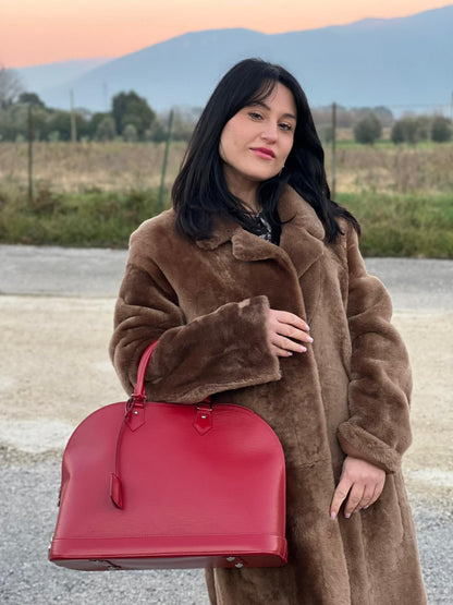 indossata della  Borsa Alma GM Louis Vuitton in pelle Epi rossa con parti metalliche argentate, munita di due manici stondati. Completa di lucchetto e chiavi, di lusso, usata, originale.