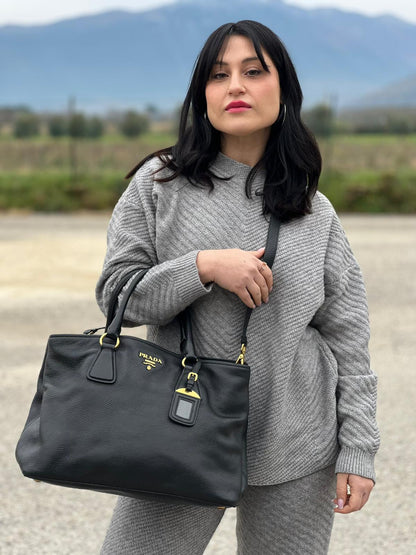 indossata Borsa Prada in pelle martellata nera con parti metalliche dorate; munita di una tracolla amovibile e regolabile e doppi manici stondati, di lusso, originale, usata 
