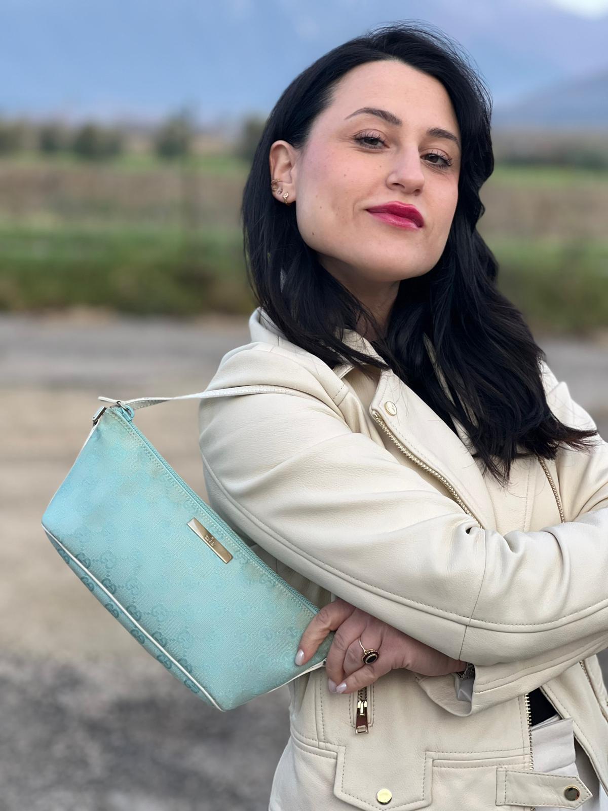 indossata  Borsa Gucci in tessuto celeste GG con finiture in pelle bianche e parti metalliche dorate, munita di un manico singolo, di lusso, originale, ottime condizioni. 