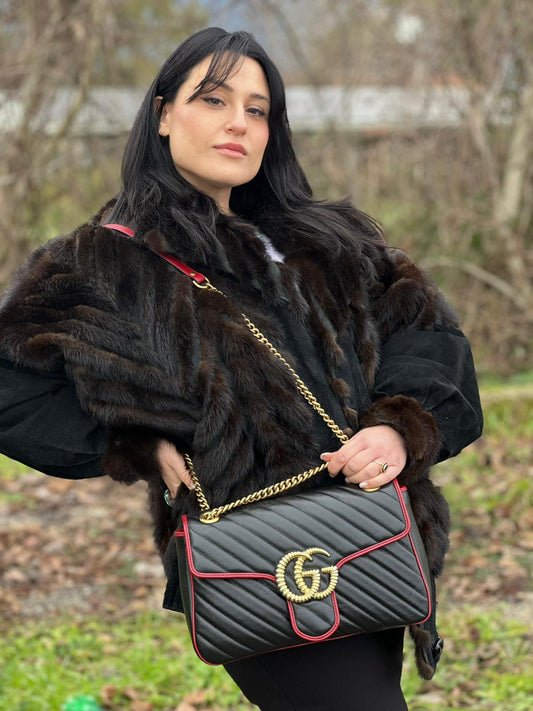 indossata Borsa Gucci Marmont in pelle matelassè nera con finiture rosse e parti metalliche dorate, impreziosita da doppia G sul front e munita di una tracolla in catena scorrevole. Full set, di lusso, eccellenti condizioni, usata. 