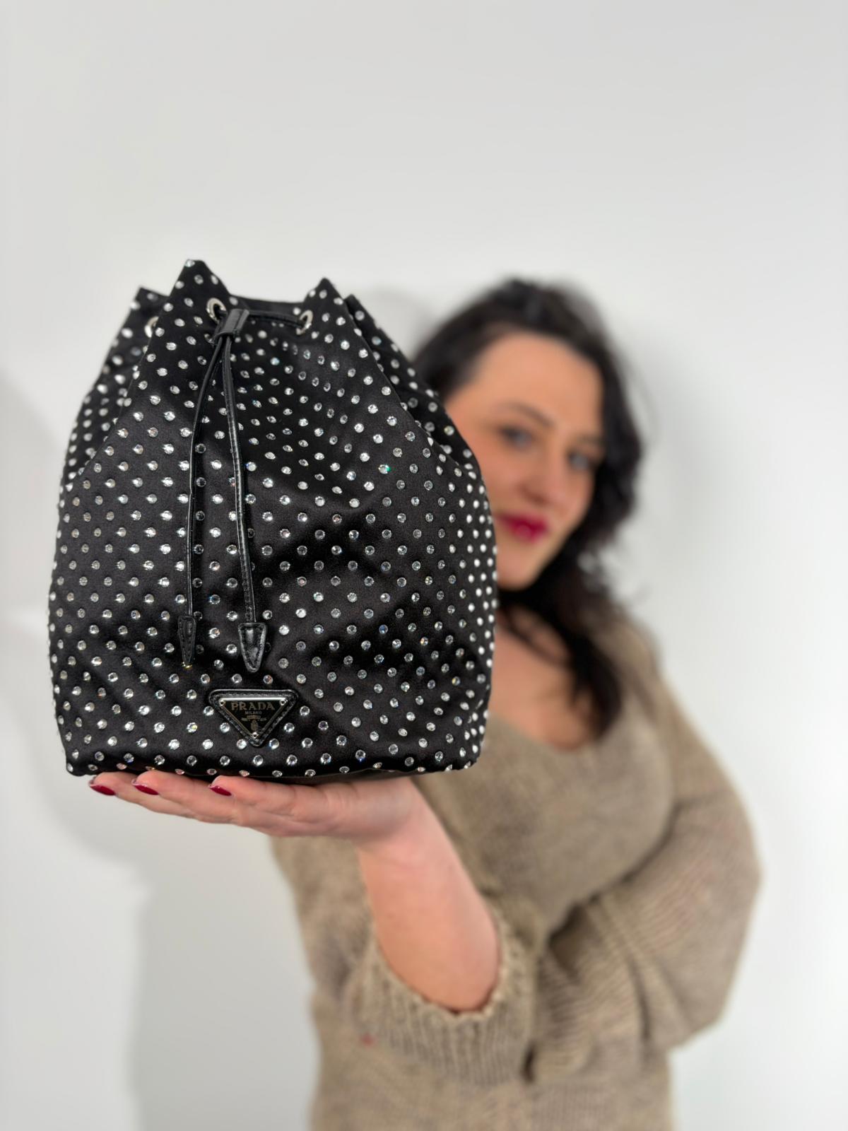Indossata, Pochette Prada Tipicamente realizzata in raso di seta nero, impreziosita da cristalli sintetici, Indossabile a mano.