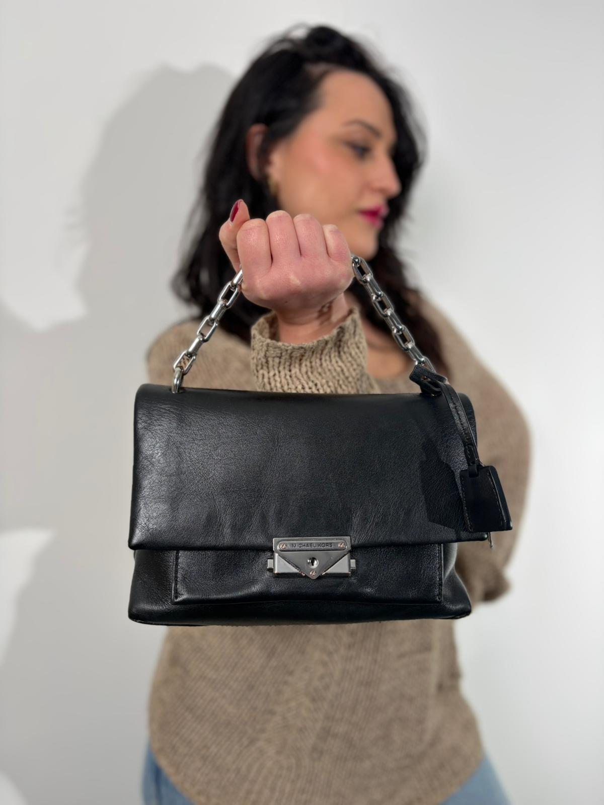 Indossata, Borsa MK in pelle con impunture trapuntate, con parti metalliche in ottone nero, indossabile a spalla o a tracolla. Originale, usata, di lusso, in ottime condizioni.