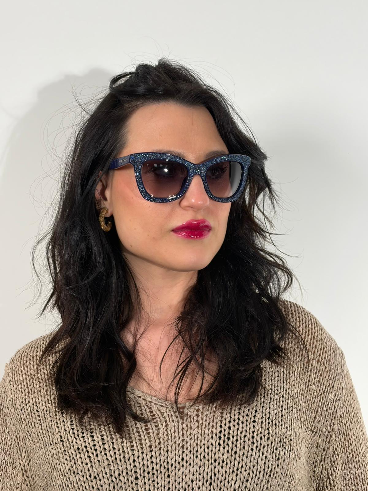 Indossata, Occhiali da sole Jimmy Choo nella variante colore FIALF Blue Grey con una montatura in acetato blu impreziosita da un effetto glitterato e lenti grigio sfumato. Originale, usati, di lusso, in ottime condizioni.