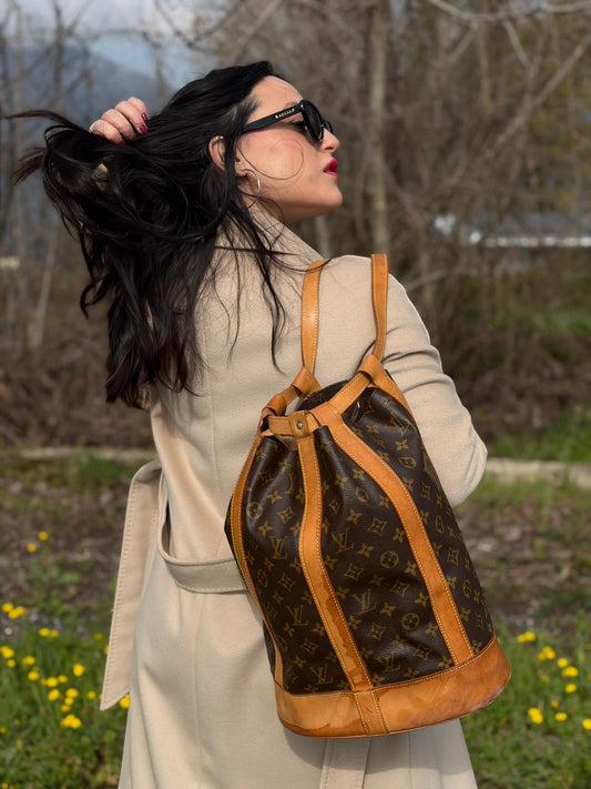 Indossata, Zaino Louis Vuitton realizzato in tela Monogram con hardware dorato, caratterizzato da una chiusura a coulisse. Indossabile a spalla.