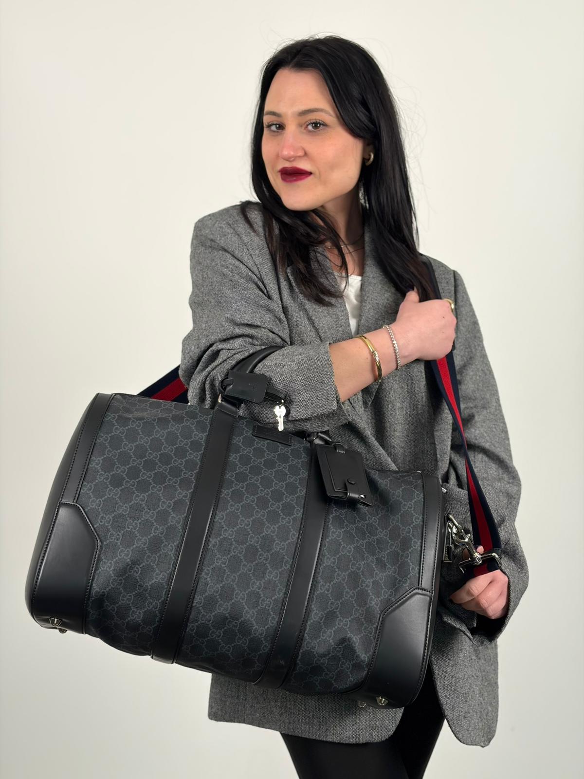 Indossata, Borsone da viaggio Gucci Savoy misura piccola in canvas GG supreme nero con parti metalliche argentate, da portare a mano oppure a spalla. Originale, usato, di lusso, in ottime condizioni.