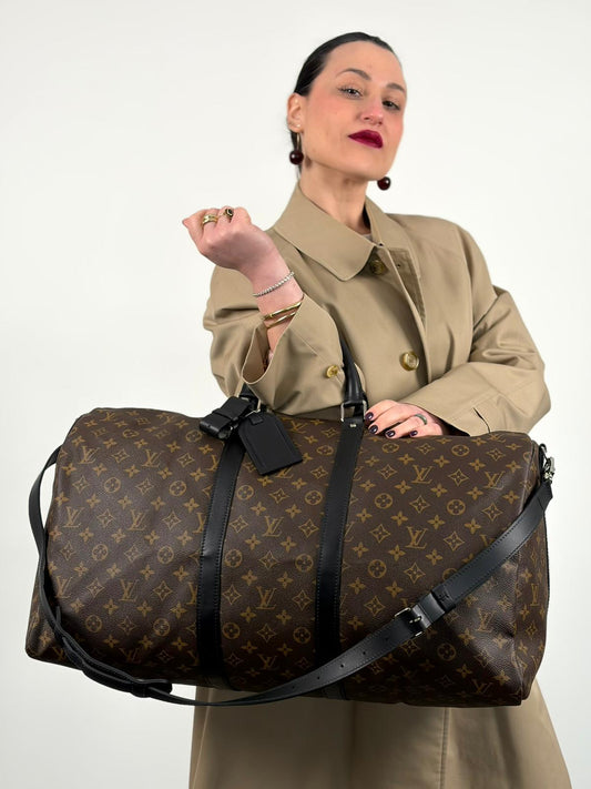 Indossata, Borsone da viaggio Louis Vuitton in canvas monogram marrone e finiture in pelle nera, metalliche argentate, da portare a mano oppure a spalla.