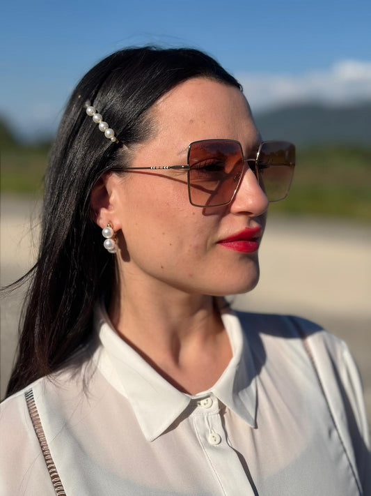 Indossati, Occhiali da sole Burberry in metallo dorato con una montatura squadrata oversize in metallo, lenti sfumate marroni o rosa.