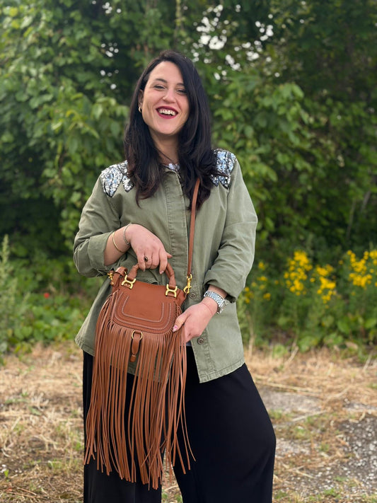 Indossata, Borsa Chloè Marcie in pelle martellata color cammello, caratterizzata da lunghe ed evidenti frange decorative. Indossabile a tracolla oppure a mano. Originale, usata, di lusso, in condizioni eccellenti.