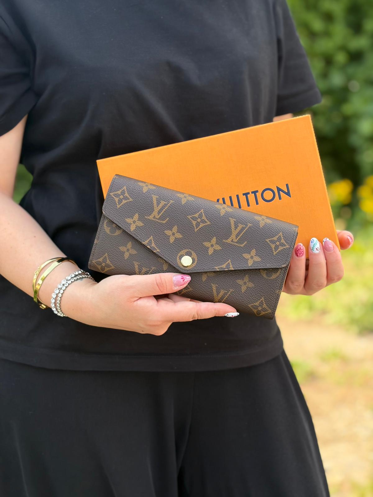 Indossata, Portafoglio Louis Vuitton Sarah in canvas monogrammato marrone, con parti metalliche dorate. Originale, usato, di lusso, in condizioni eccellenti.