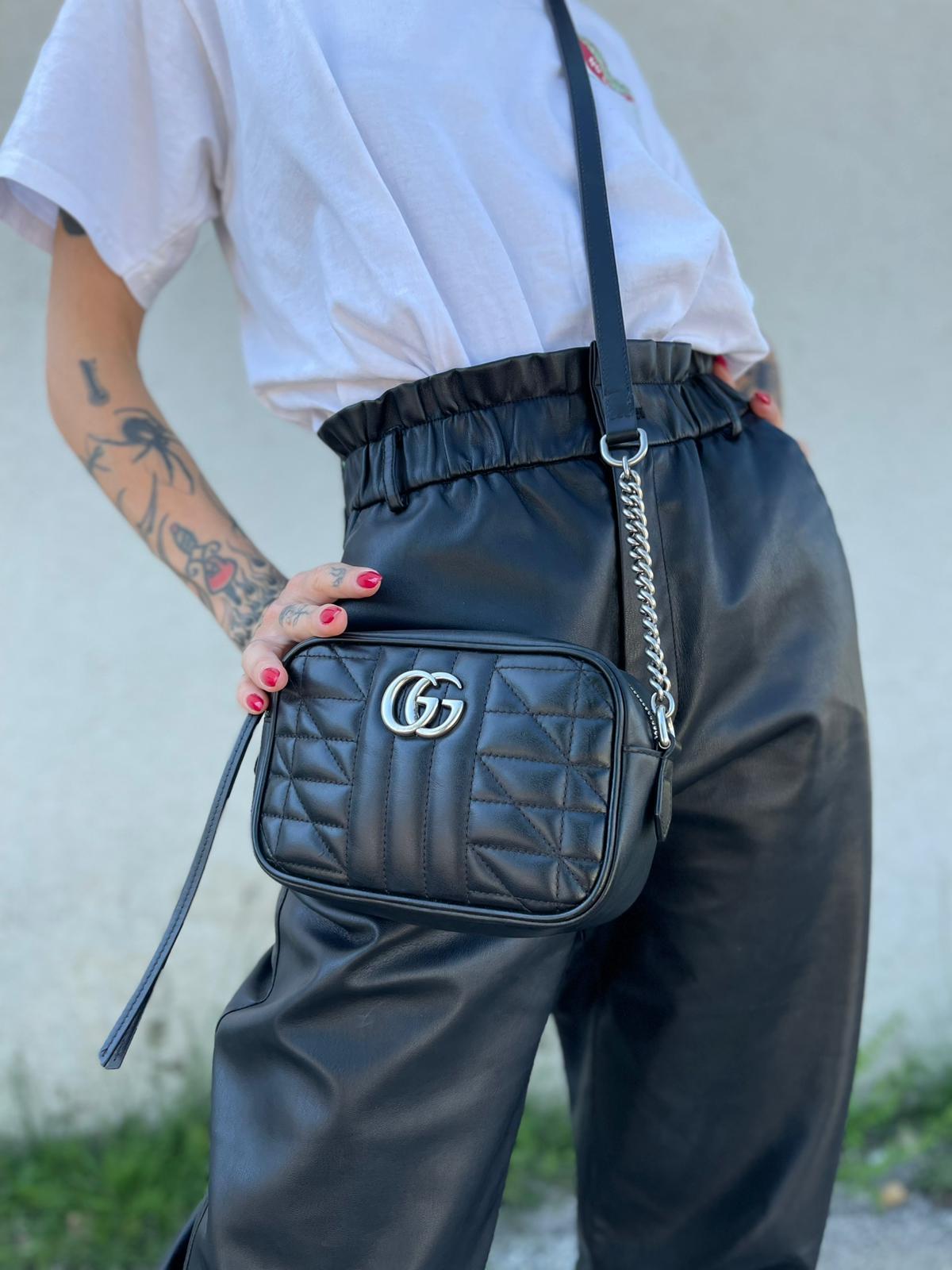 Indossata, Mini bag Gucci Marmont in pelle nera nella misura piccola, con hardware argentato, indossabile a tracolla. Originale, usata, di lusso, in ottime condizioni.