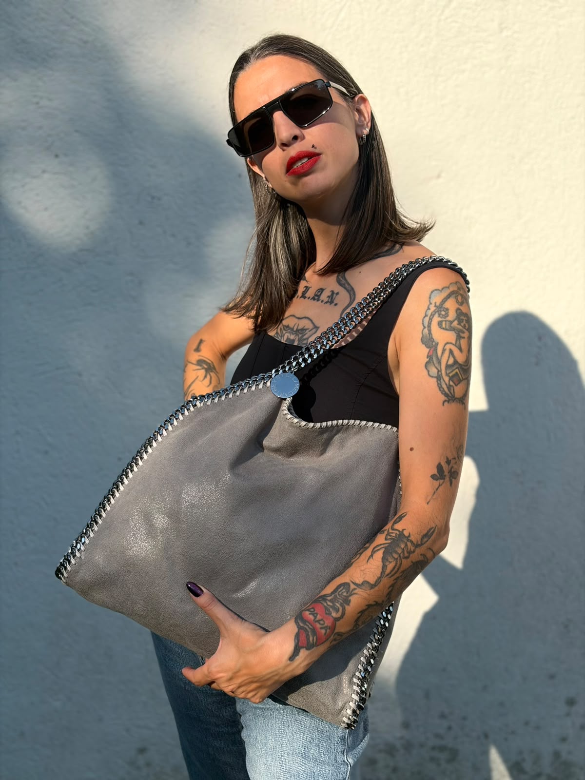 Indossata, Borsa Falabella nella versione fold over tote in tessuto vegano grigio e hardware argentato. Indossabile a spalla. Originale, usata, di lusso, in ottime condizioni.