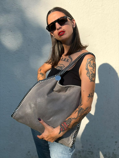 Indossata, Borsa Falabella nella versione fold over tote in tessuto vegano grigio e hardware argentato. Indossabile a spalla. Originale, usata, di lusso, in ottime condizioni.