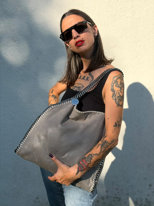 Indossata, Borsa Falabella nella versione fold over tote in tessuto vegano grigio e hardware argentato. Indossabile a spalla. Originale, usata, di lusso, in ottime condizioni.