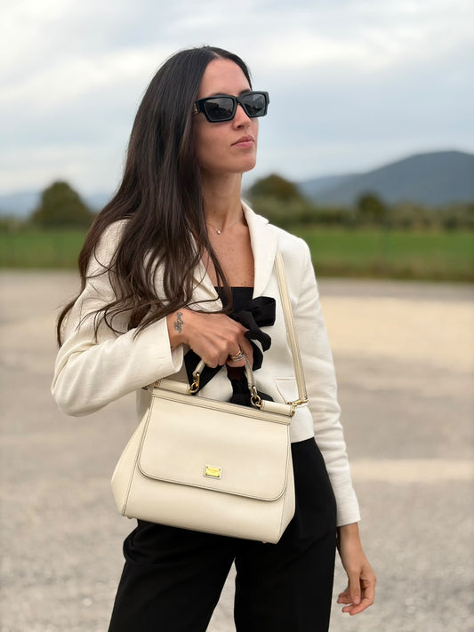 Indossata, Borsa Sicily nella misura grande, realizzata in pelle color bianco latte, Dalla linea essenziale e femminile, è personalizzata da targhetta logata bigalvanica. Originale, usata, di lusso, in ottime condizioni.