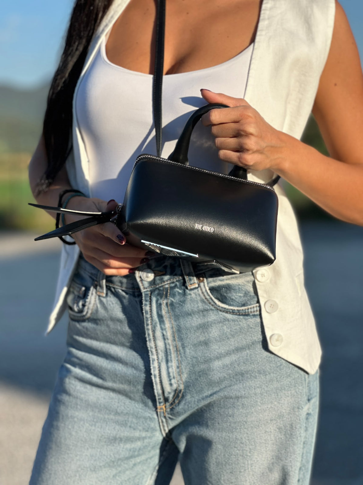 Indossata, Borsa The Attico in pelle nera rifinita con parti metalliche argentate; munita di un manico singolo e una tracolla amovibile che diventa anche marsupio. Originale, usata, di lusso, in ottime condizioni