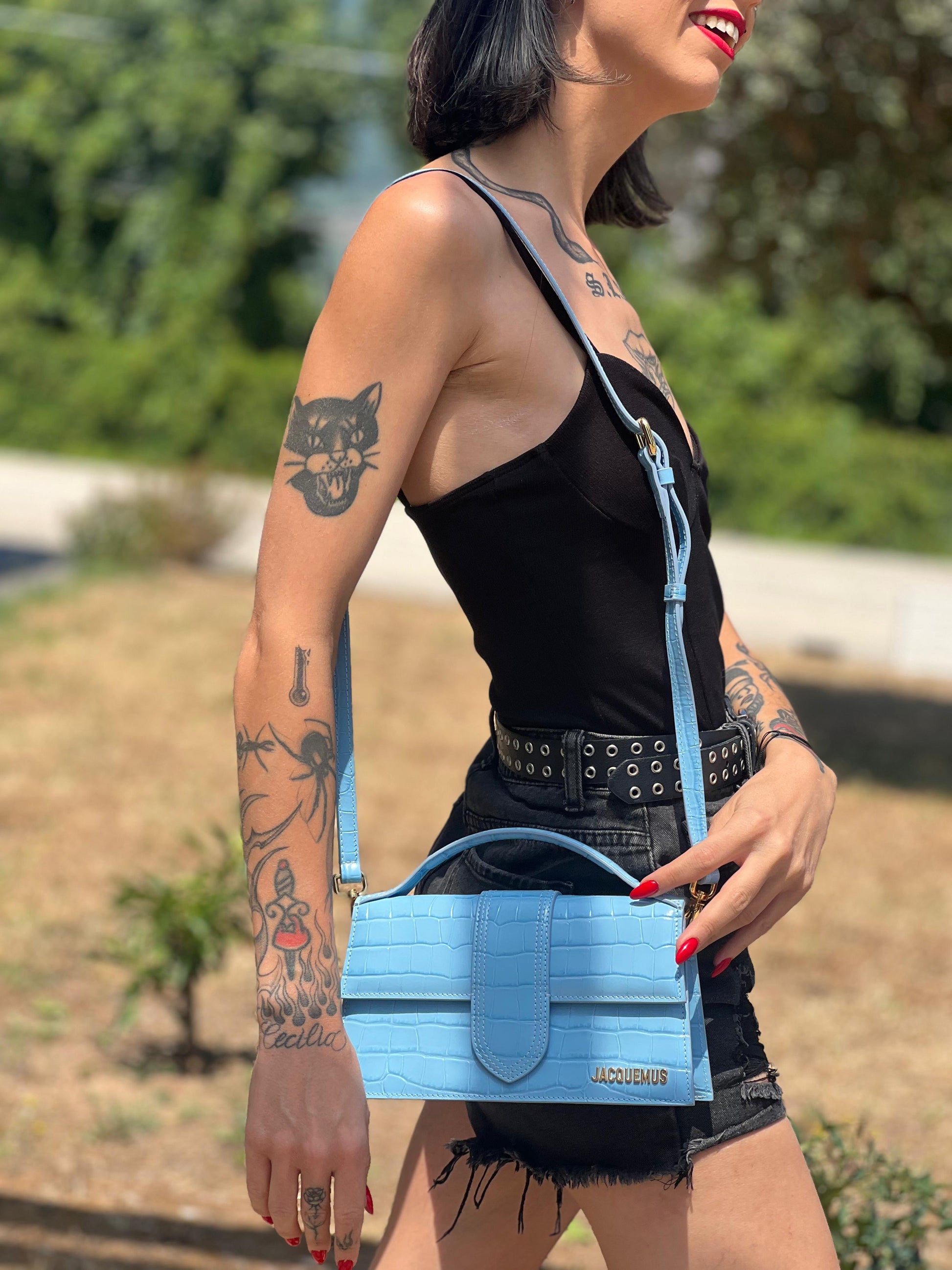 Borsa Jacquemus in pelle azzurra trama cocco con parti metalliche dorate; munita di un manico singolo e una tracolla amovibile e regolabile, indossata 
