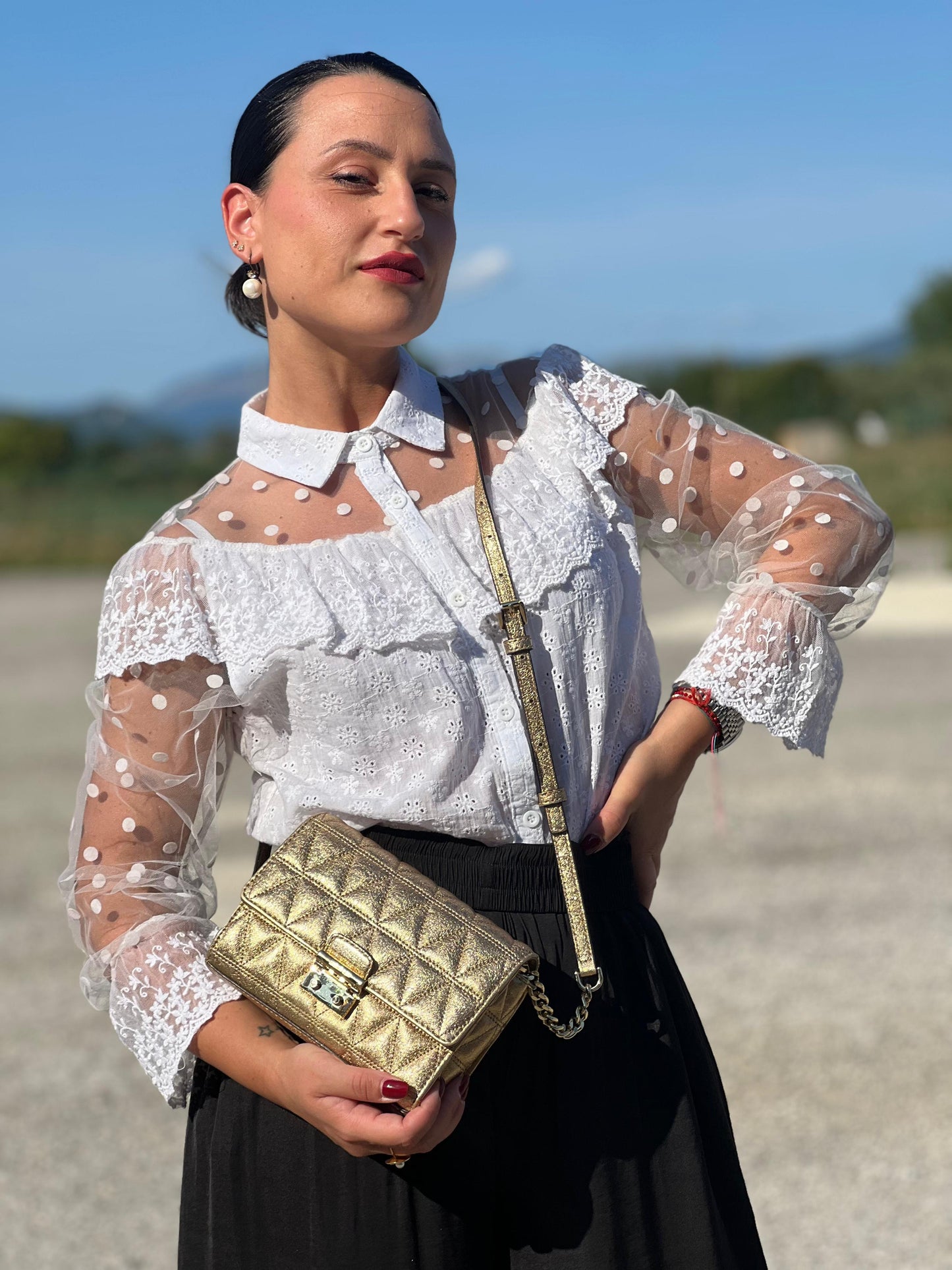 indossata  Borsa Michael Kors pelle dorata rifinita con inserti metallici tono su tono, munita di una tracolla regolabile 