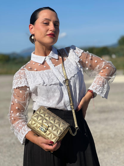 indossata  Borsa Michael Kors pelle dorata rifinita con inserti metallici tono su tono, munita di una tracolla regolabile 