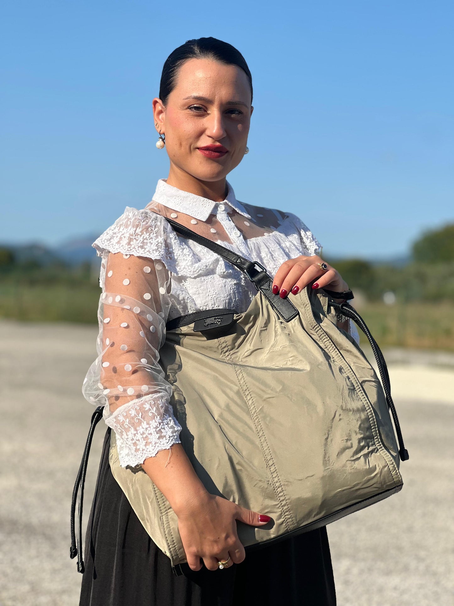 indossata Borsa Burberry in nylon color sabbia rifinita con parti in pelle nere e inserti metallici effetto renio; munita di doppi manici, da indossare a spalla 