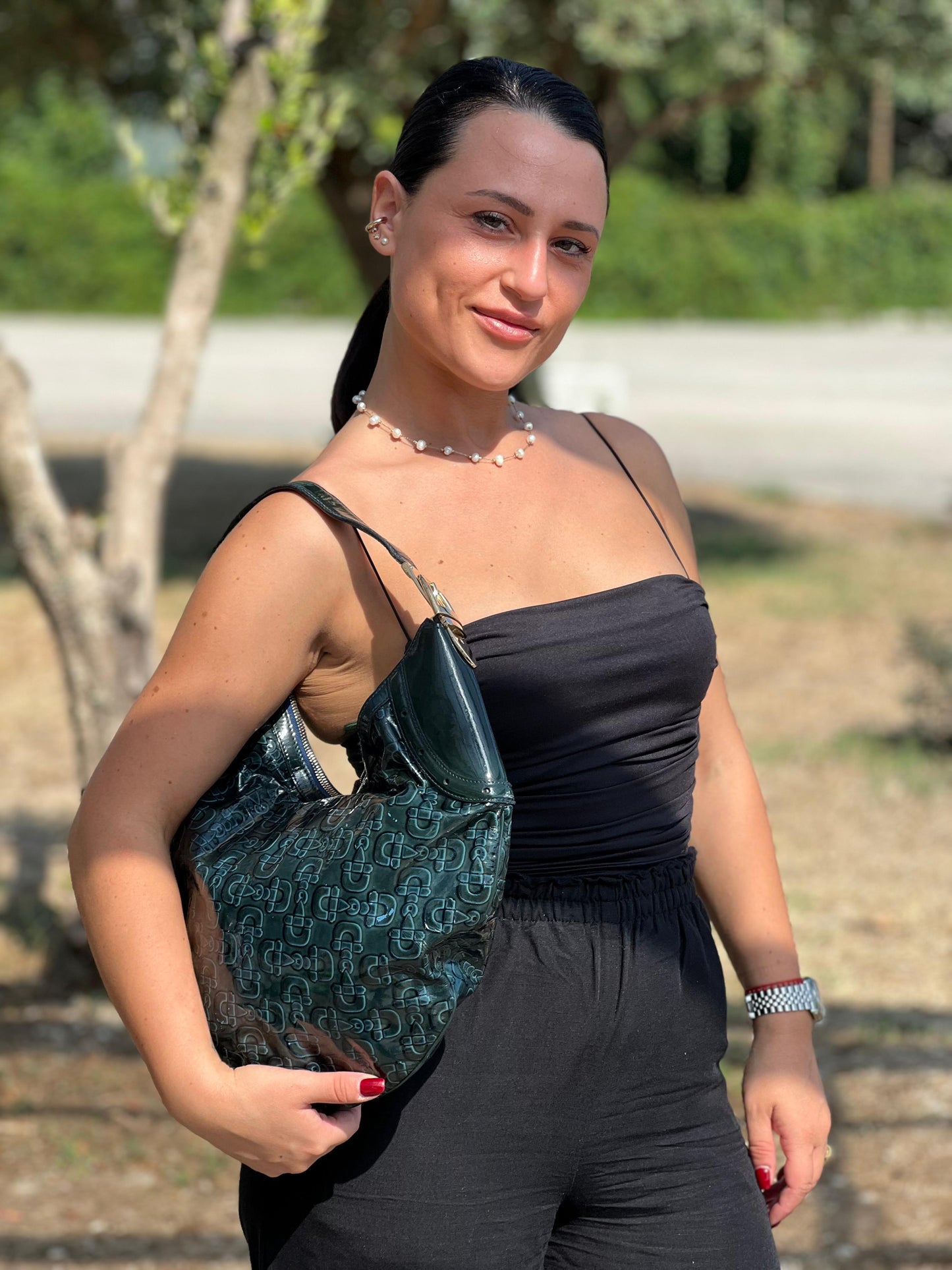 indossata Borsa Gucci in pelle verniciata verde petrolio con trama Horsebit; munita di un manico singolo e impreziosita da inserti metallici dorati. 