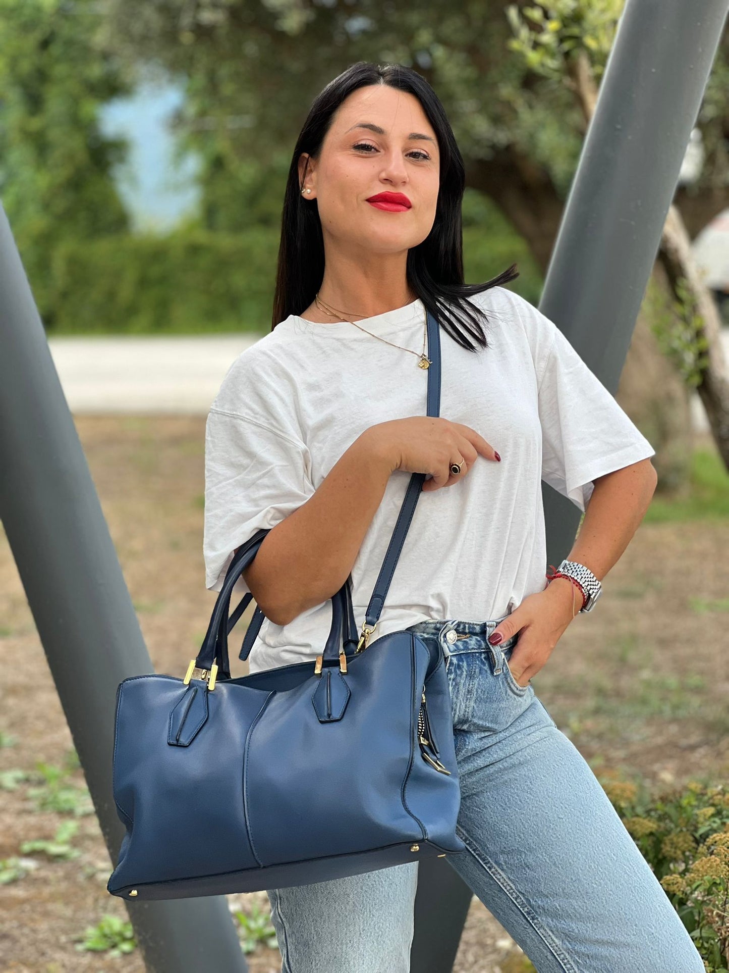 indossata Bauletto Tod's in pelle blu con parti metalliche dorate; munita di doppi manici stondati e una tracolla amovibile e regolabile 