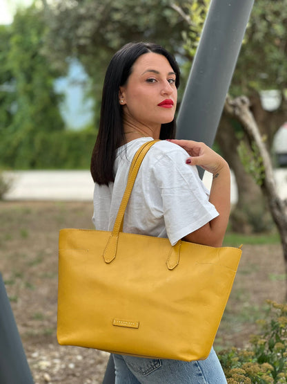 indossata Borsa The Bridge in pelle gialla con parti metalliche dorate; munita di doppi manici, da indossare a spalla 